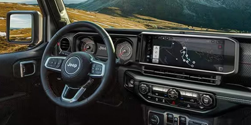 The interior dashboard of a Jeep featuring a steering wheel
