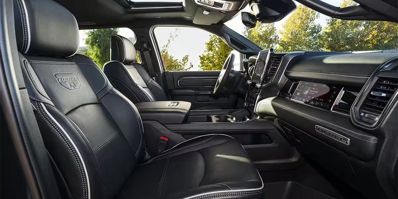 A detailed view of a RAM truck interior showing black leather seats