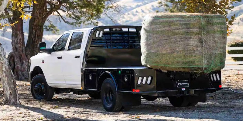 A white heavy-duty pickup truck with a black flatbed parked outdoors